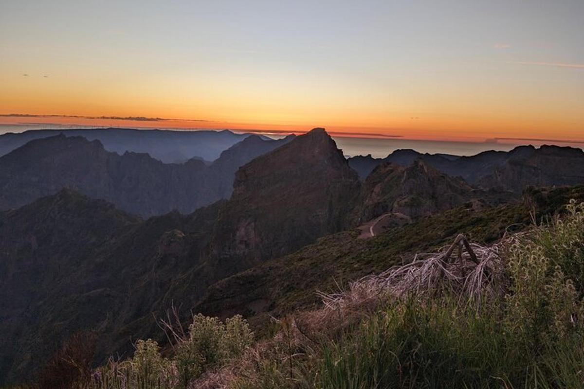 a view of a mountain with the sun setting on the horizon