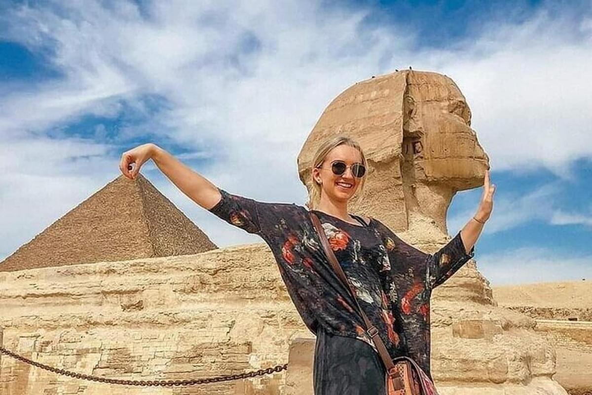 a woman is standing in front of a pyramid