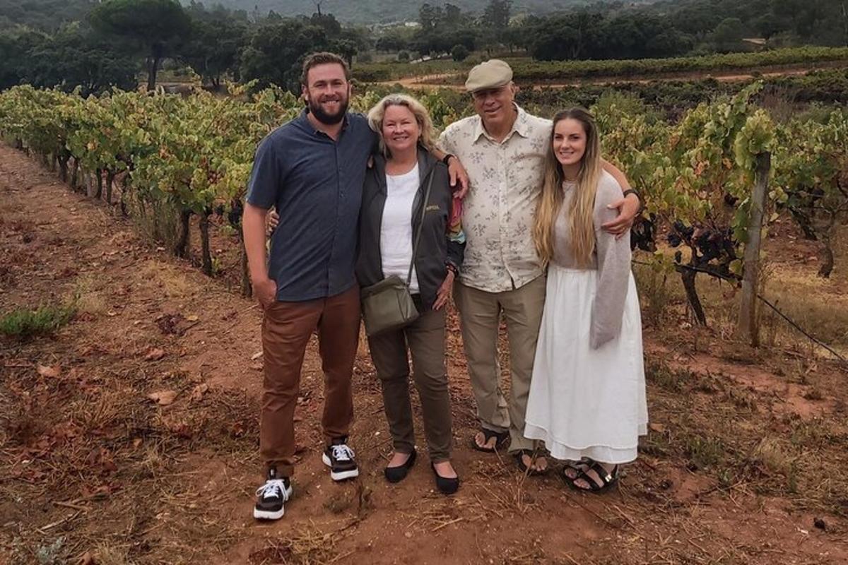 a group of people standing in front of a vineyard