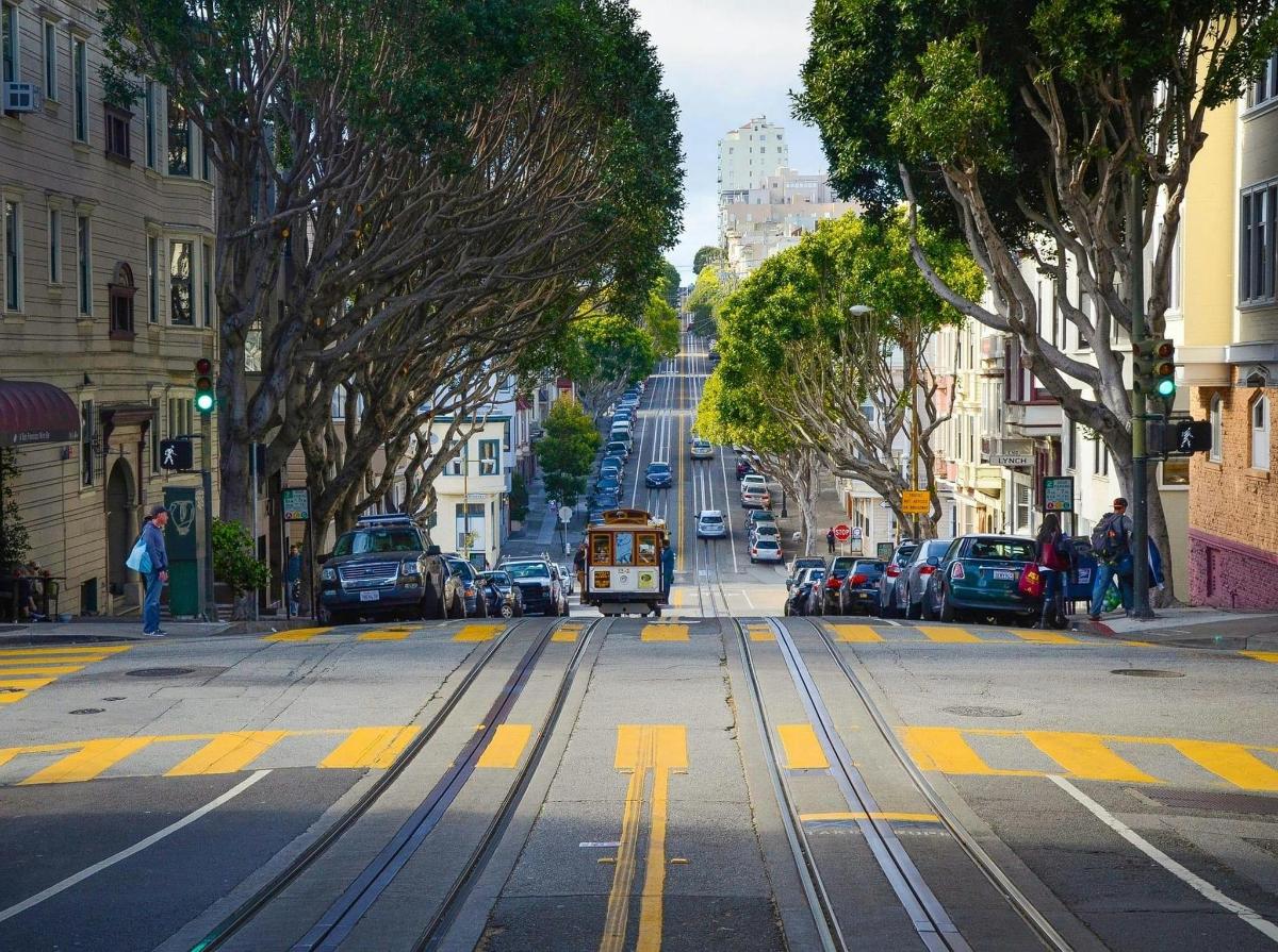 a trolley car driving down a busy city street