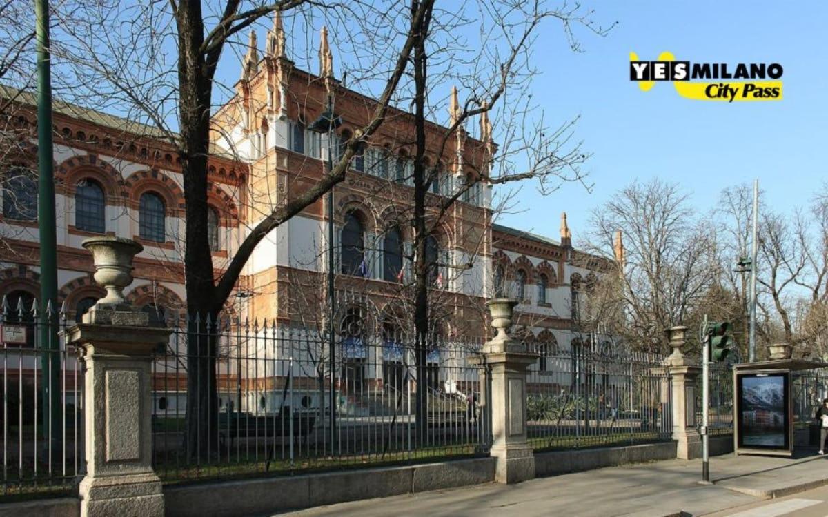 Un gran edificio con una valla delante.