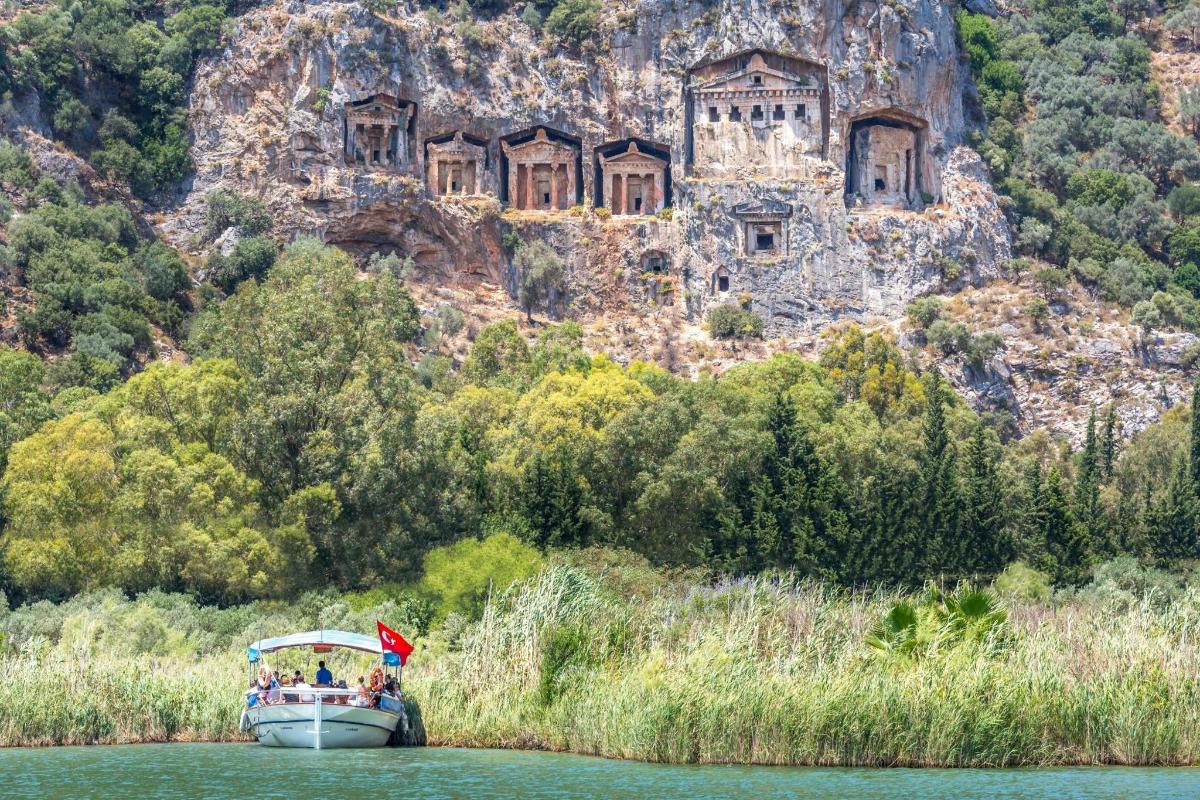 un vaixell a l'aigua davant d'una formació rocosa
