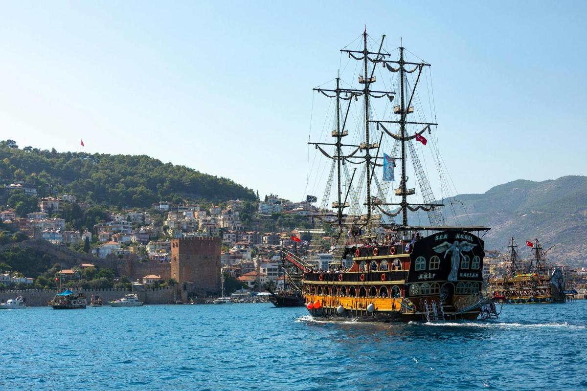 a pirate ship in the water near a city