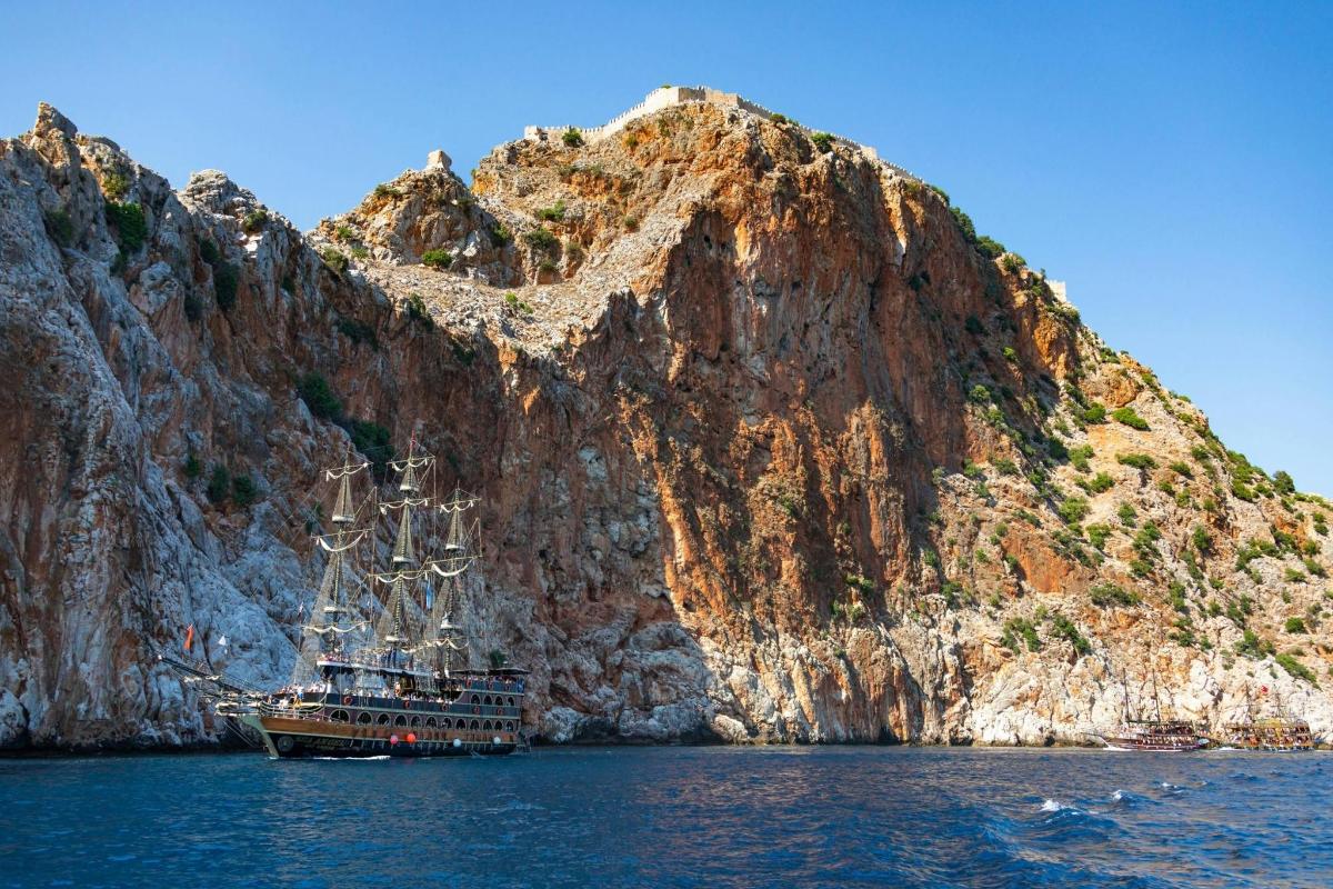 un vaixell a l'aigua al costat d'una muntanya