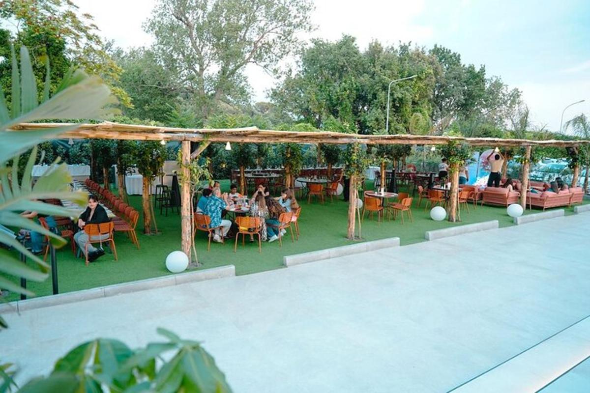 a group of people sitting at tables in a garden