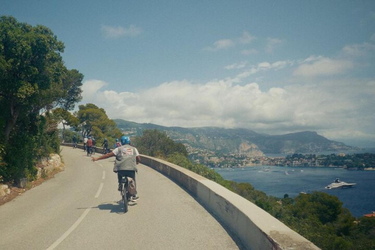 un uomo in bicicletta su una strada vicino all'acqua