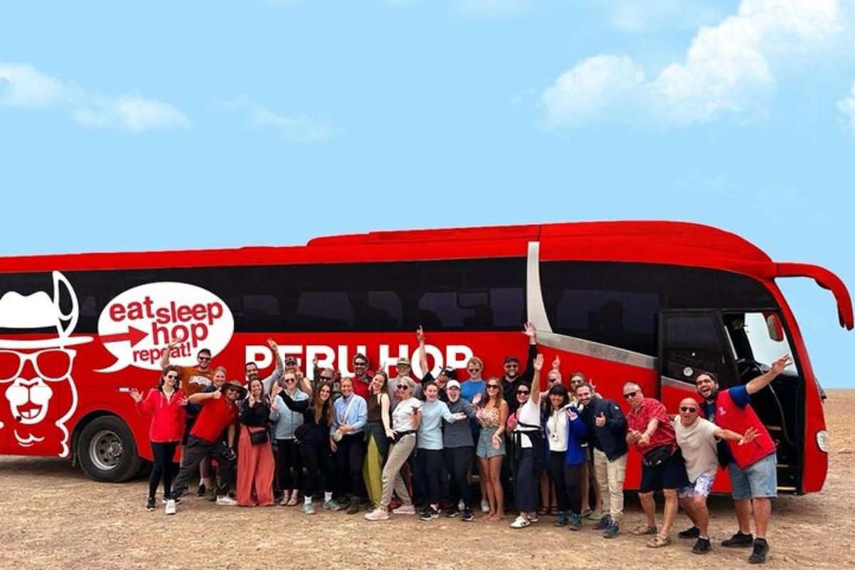 skupina lidí stojících před červeným autobusem