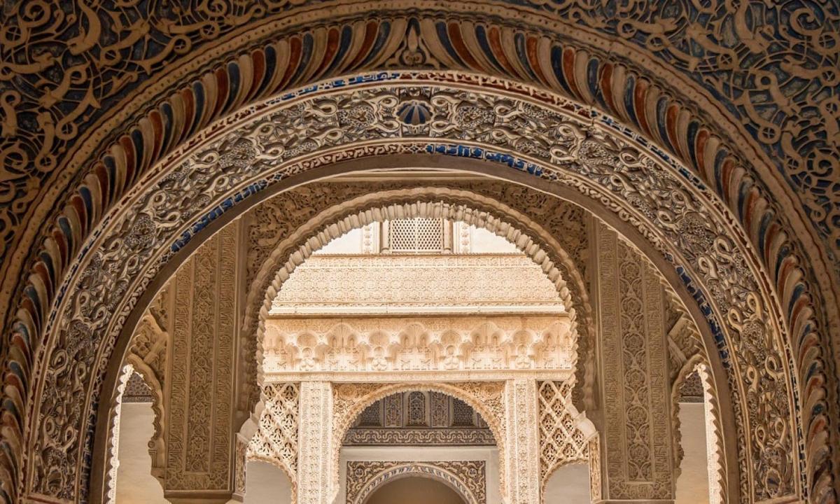 Un arco en un edificio con un edificio al fondo.