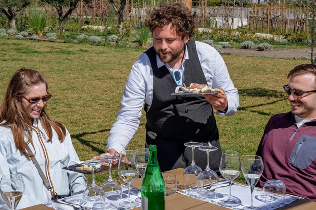 un home que sosté un plat de menjar a una taula