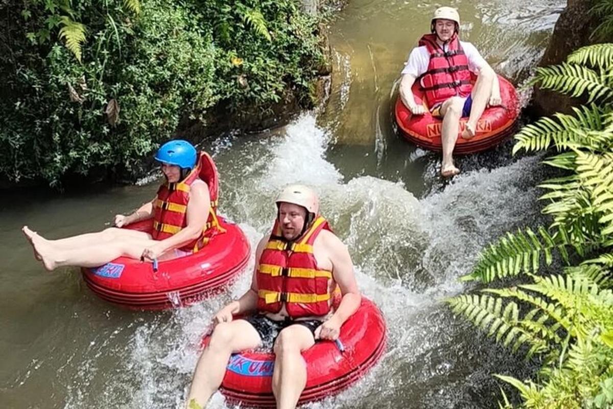 tři lidé jedoucí na raftech v řece