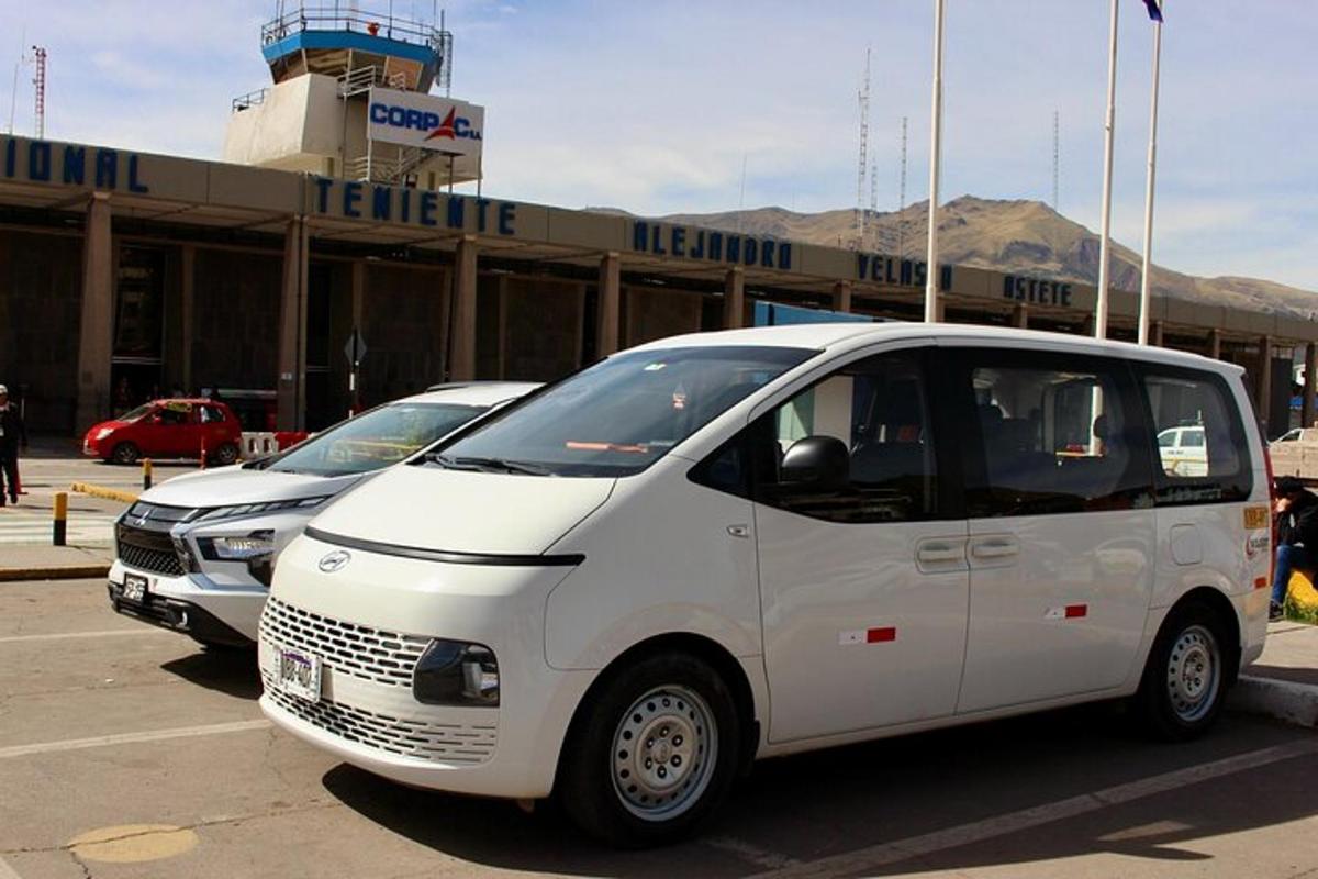 duas vans brancas estacionadas em frente a um aeroporto