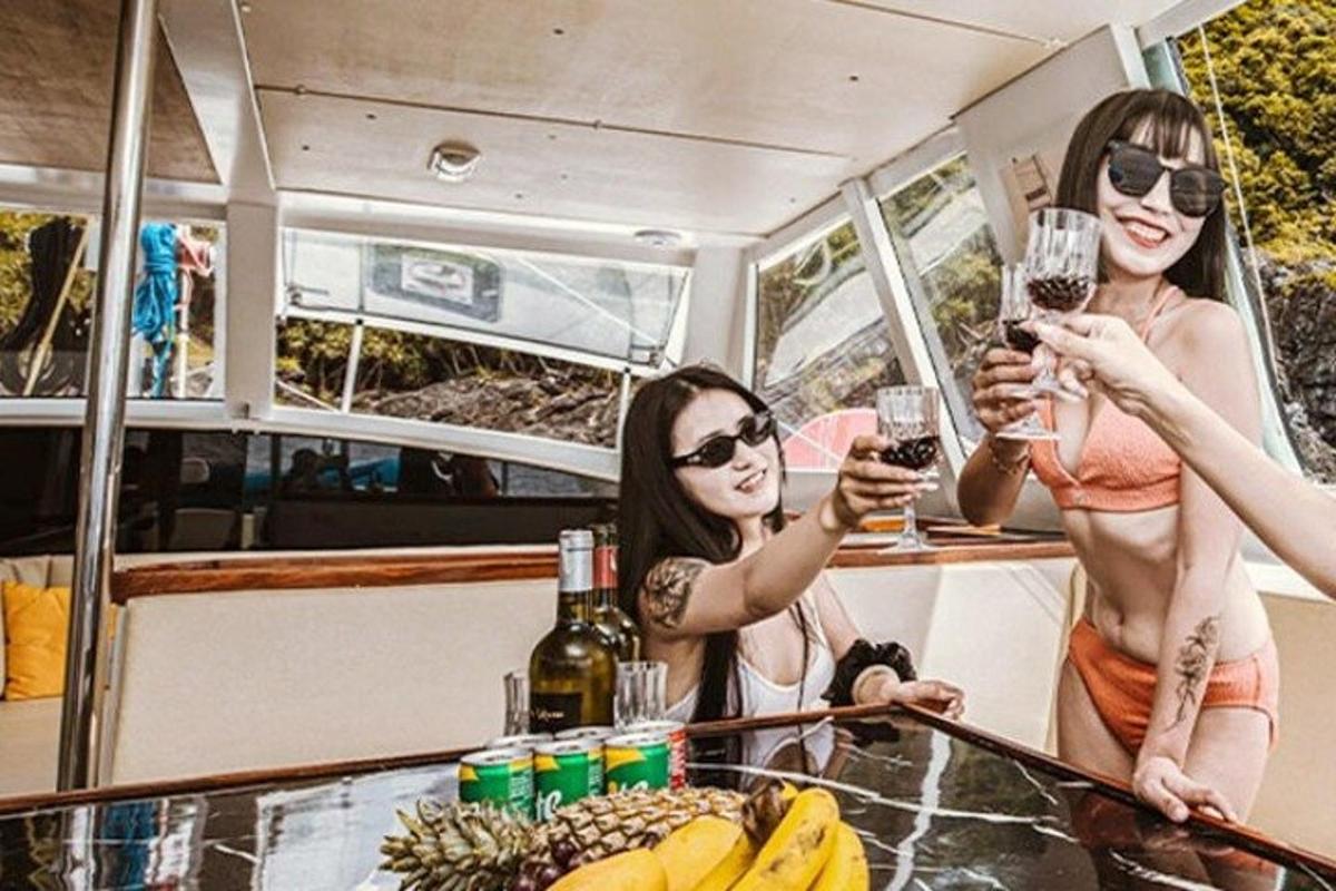три жене држећи чаше вина на броду