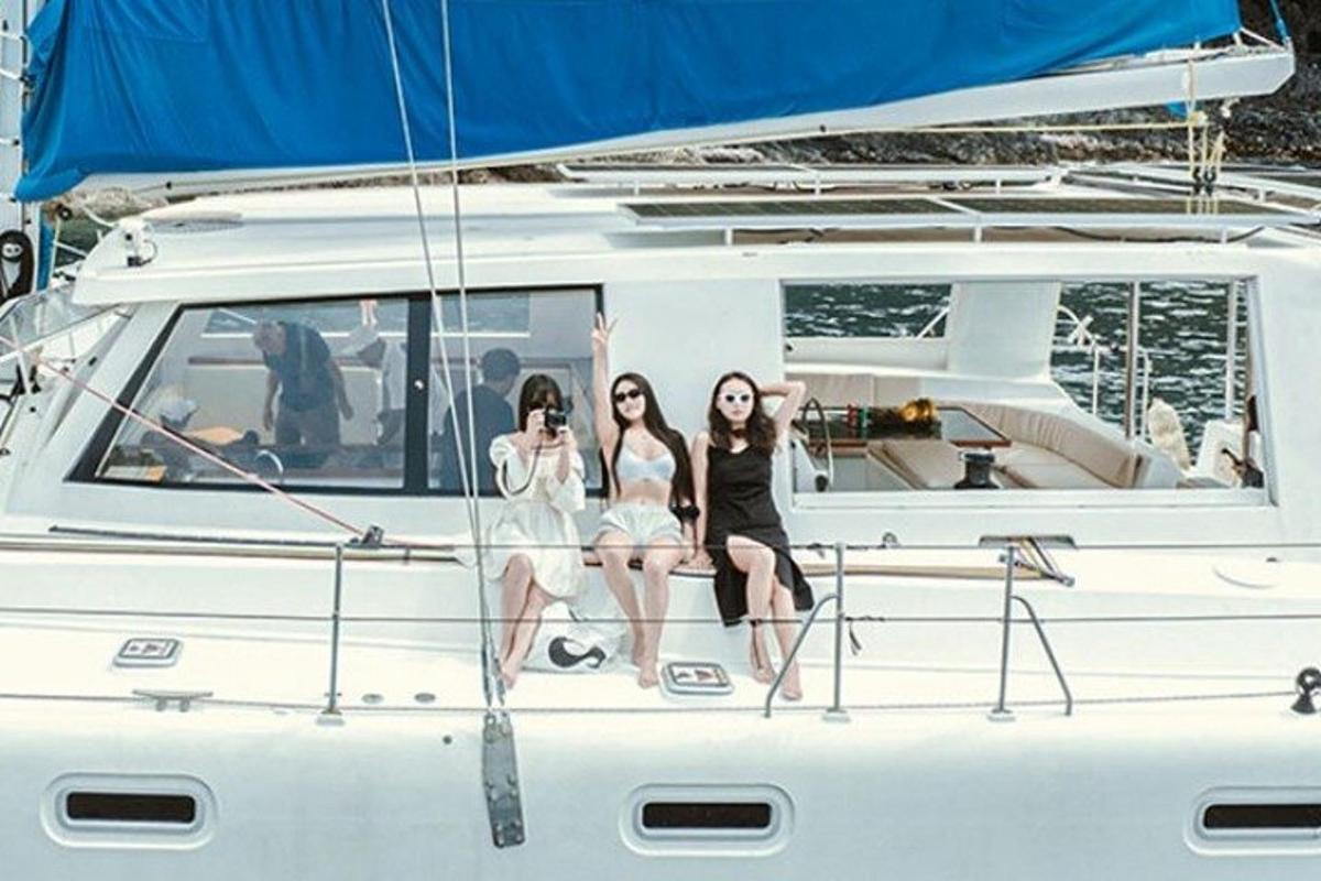 tiga wanita duduk di depan perahu