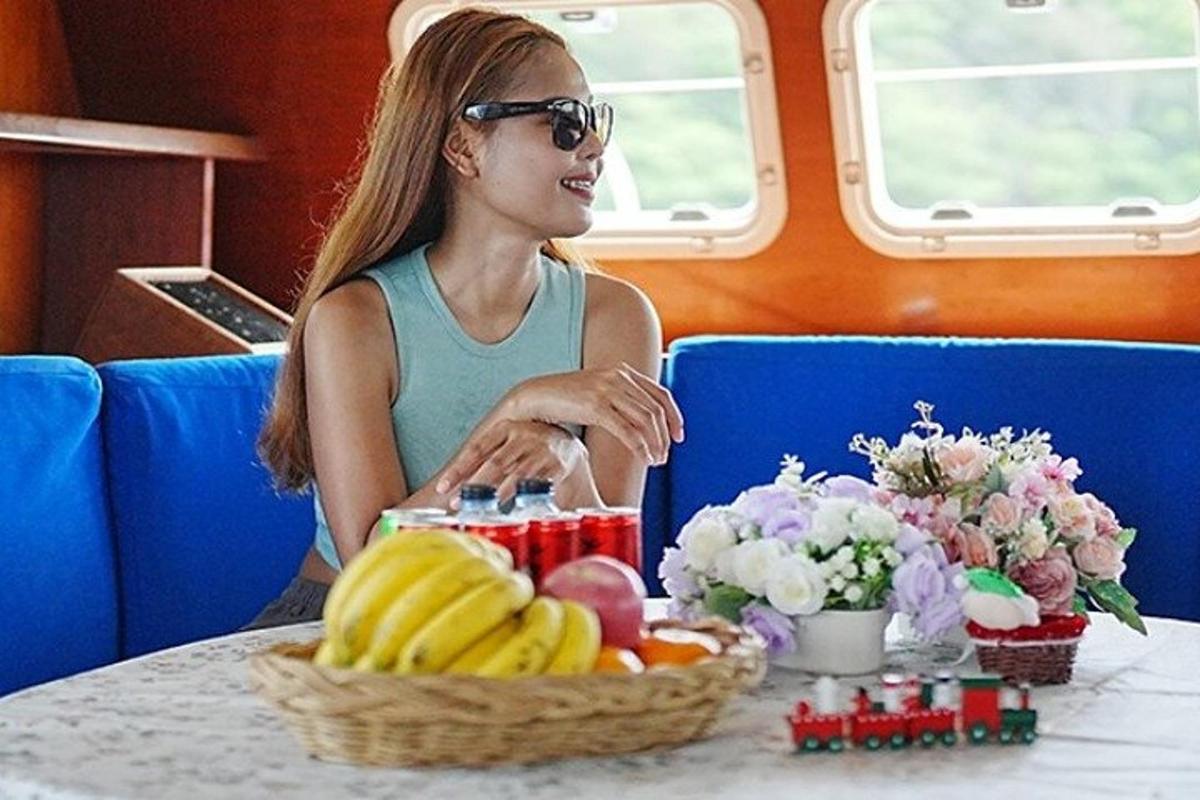 uma mulher sentada à mesa com uma cesta de frutas