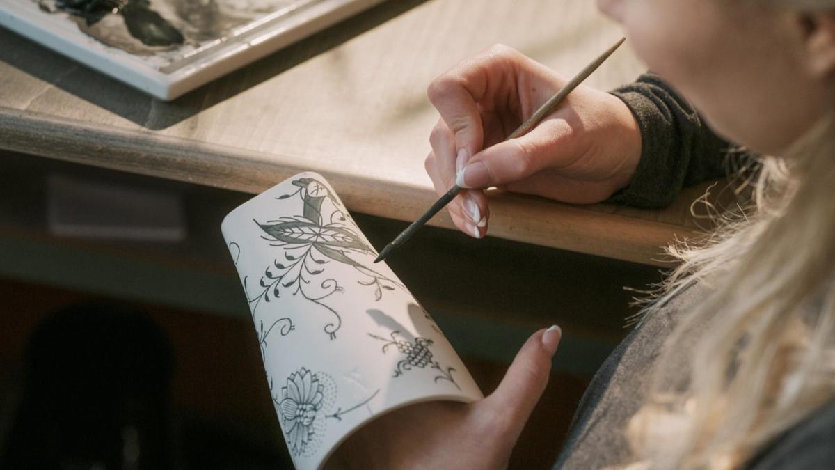 a woman cutting a piece of paper with scissors