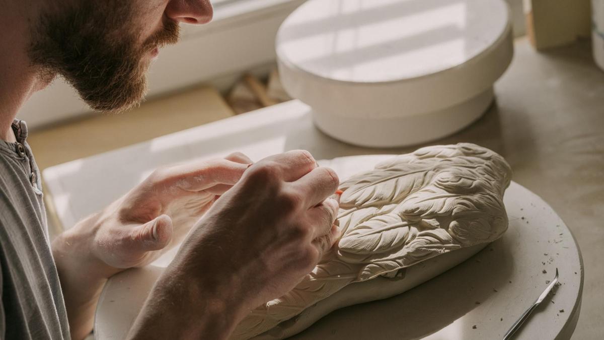 a man is working on a sculpture on a table