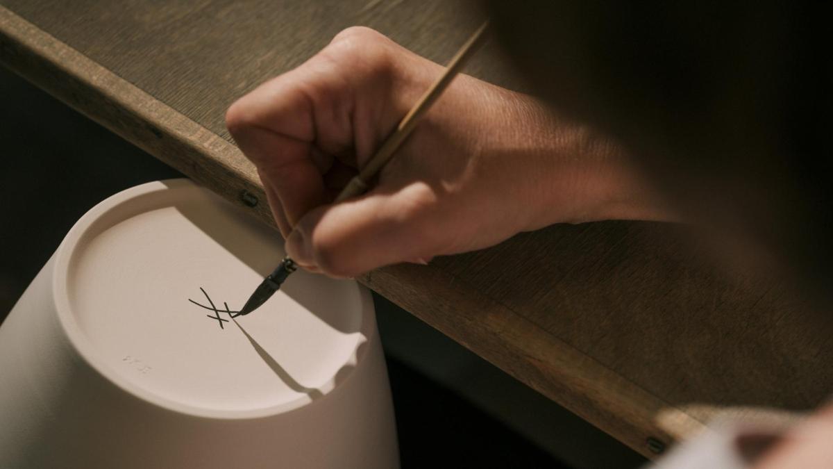 a person holding a cigarette in front of a toilet