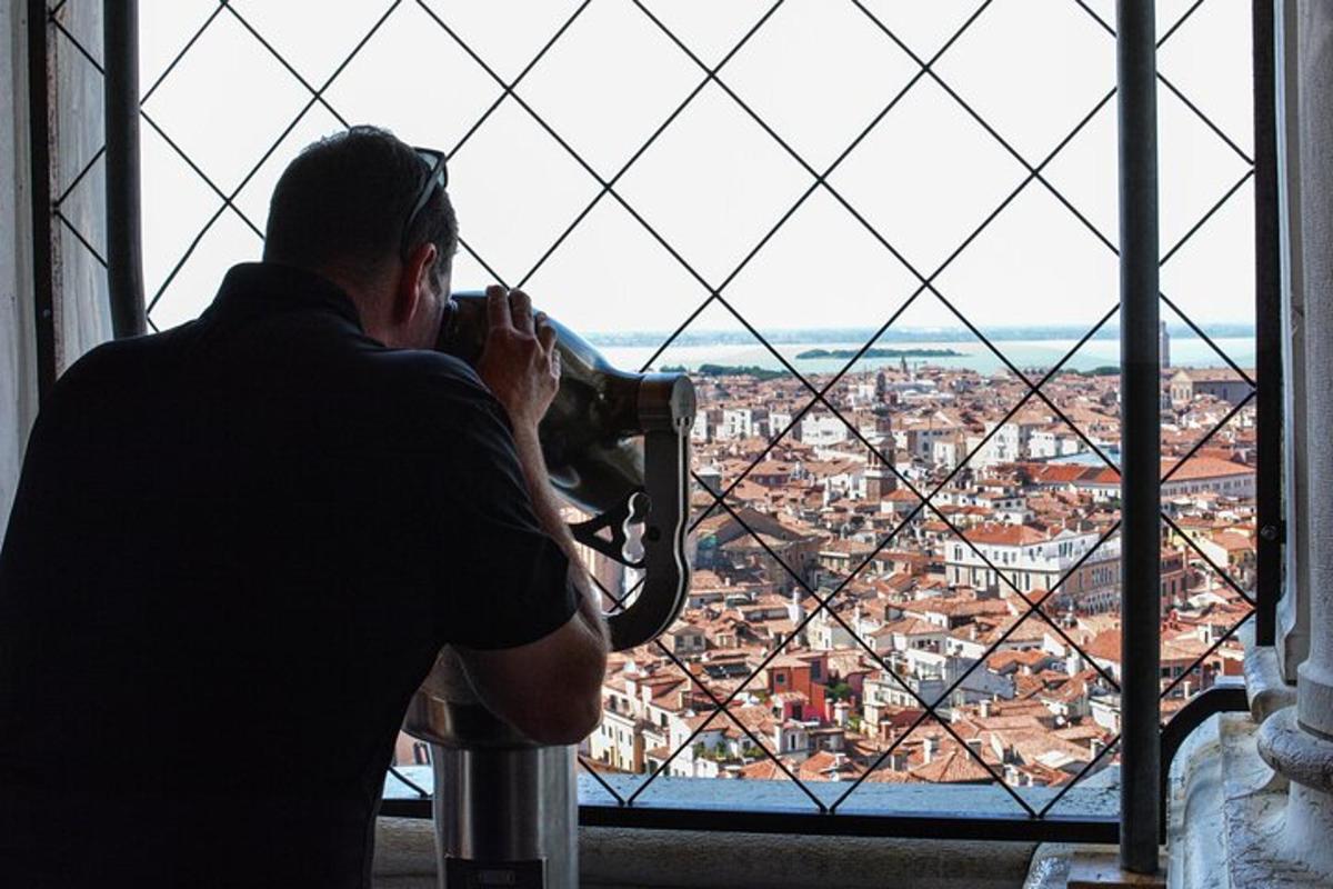 Un hombre tomando una fotografía de una ciudad desde una ventana.