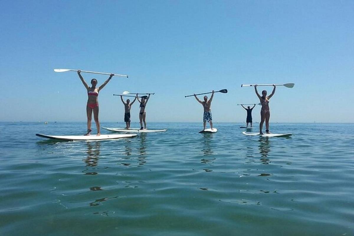 eine Gruppe von Menschen steht auf Surfbrettern im Wasser