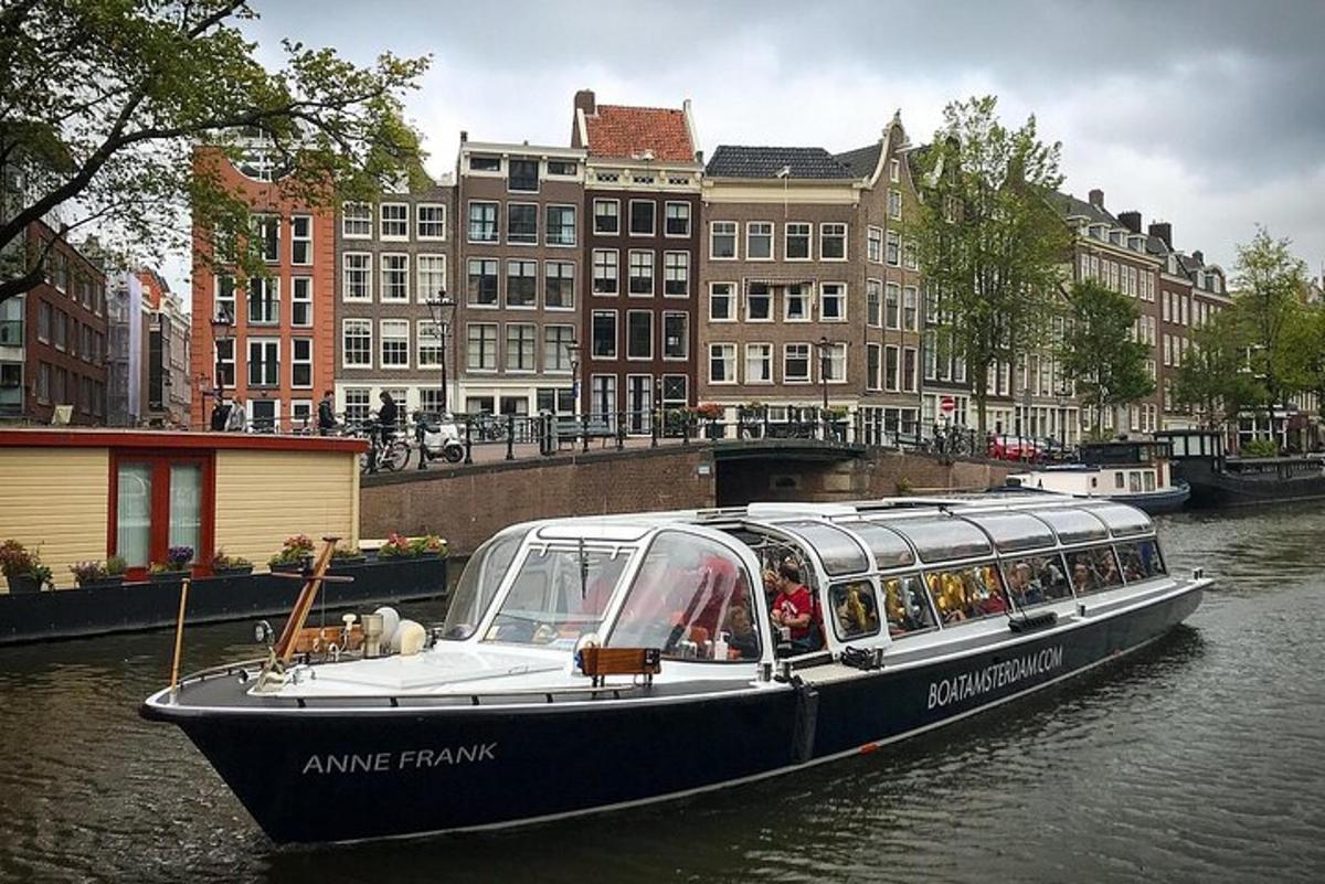 un vaixell ple de gent en un riu amb edificis