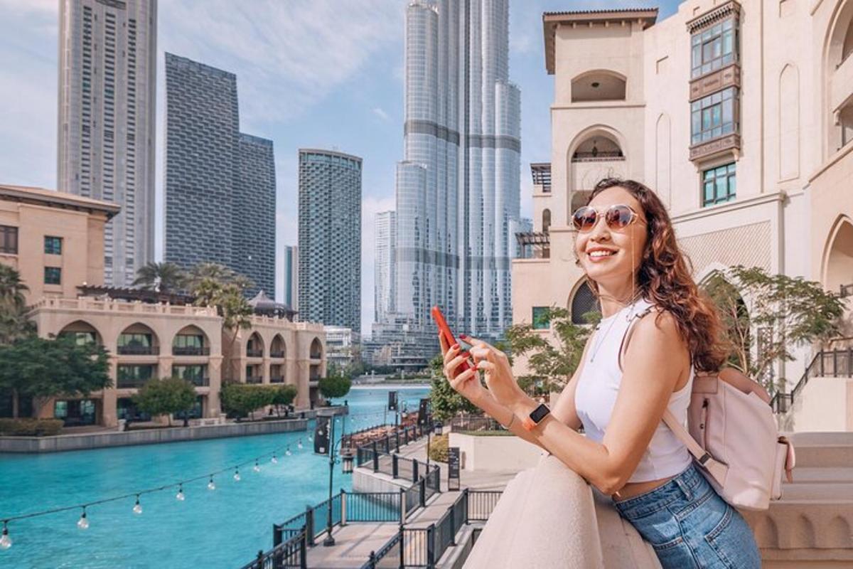 a woman holding a cell phone in front of a city