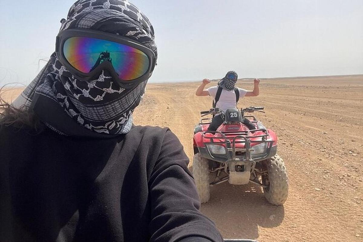 dua orang menunggang basikal quad di padang pasir