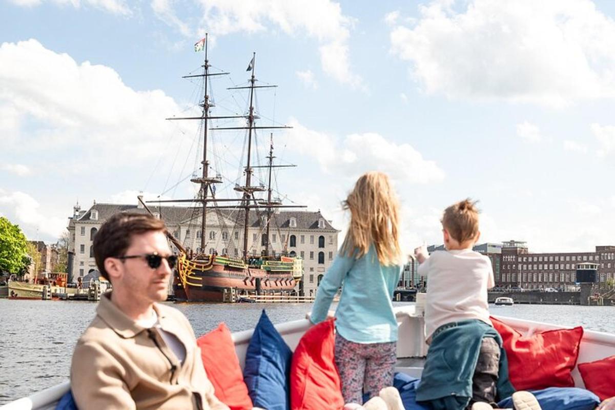 Maður og tvö börn á bát með sjóræningjaskipi