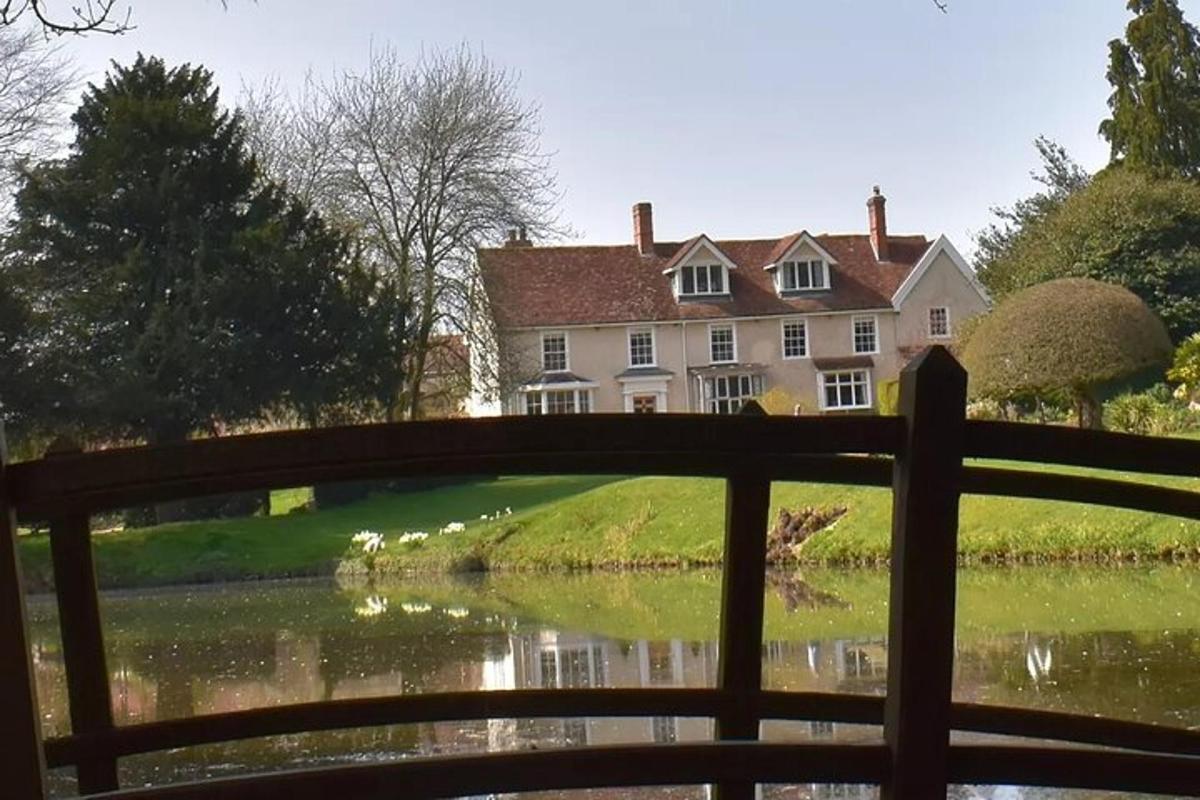 a bridge over a lake with a house in the background