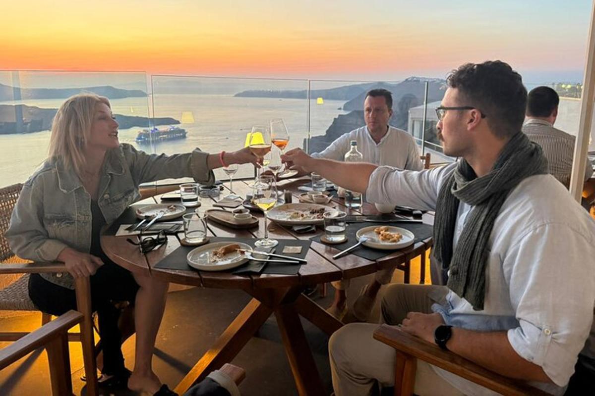um grupo de pessoas sentadas à mesa com taças de vinho
