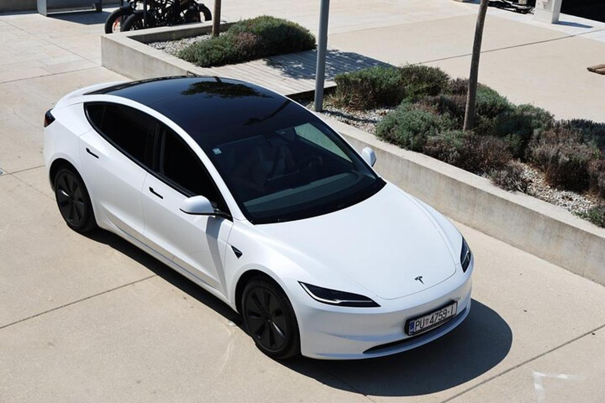 bílé auto je zaparkované na chodníku