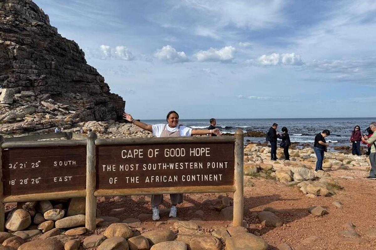 egy férfi egy tábla mögött áll a strandon
