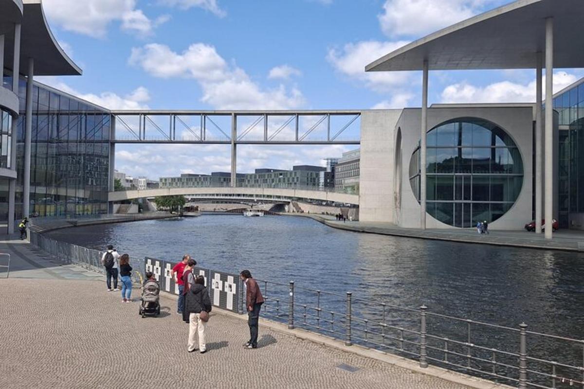 Un grupo de personas de pie cerca de un río con un puente.