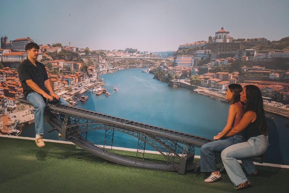 Dos personas sentadas en un puente con vistas a un río.