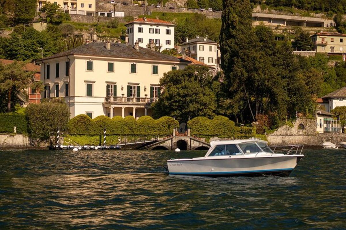 una barca bianca nell'acqua di fronte a una casa