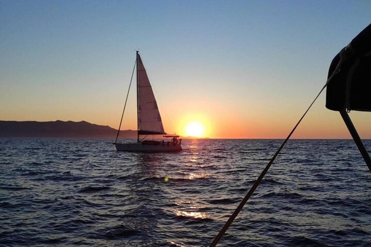 a sailboat in the ocean at sunset