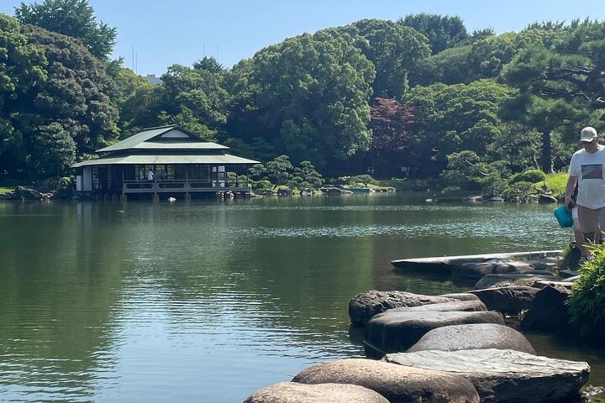 un home dret a la vora d'un llac amb un edifici