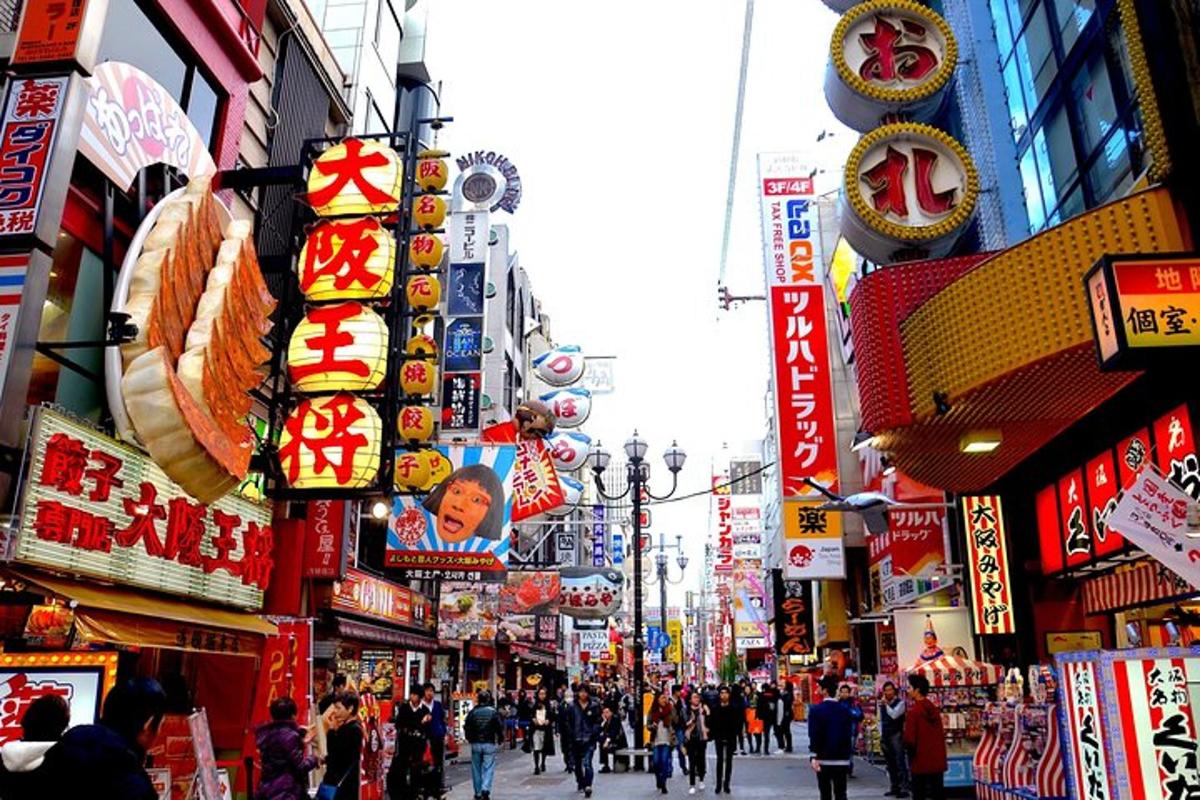 Una calle muy transitada en una ciudad asiática con muchos carteles.