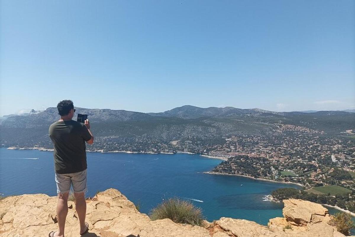 Un hombre parado en la cima de una montaña tomando una fotografía