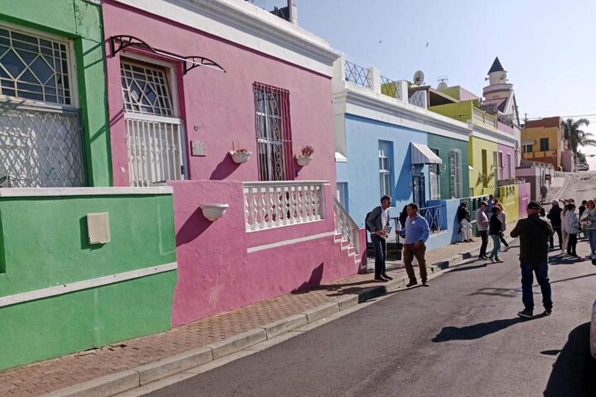 a group of people walking down a street with colorful buildings