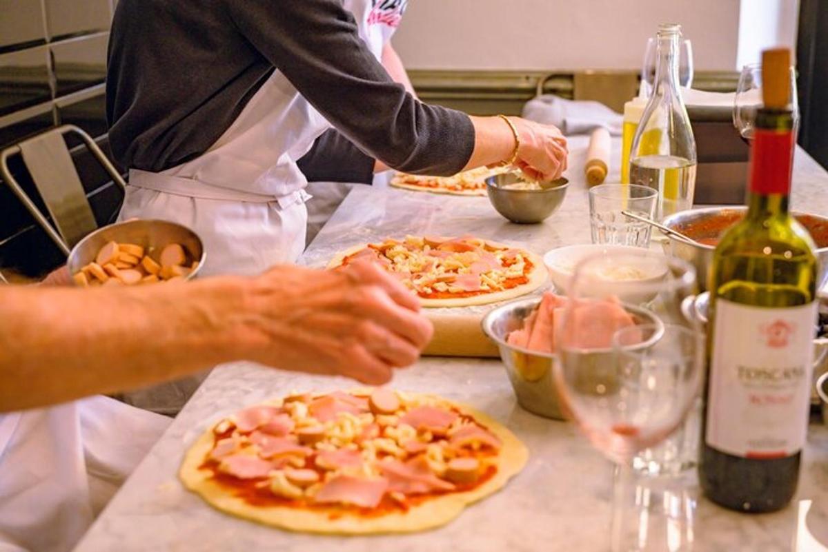dva lidé pečou pizzu na kuchyňské lince