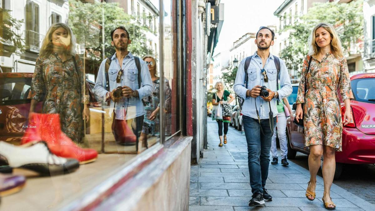 moški in ženska hodita po ulici pred trgovino