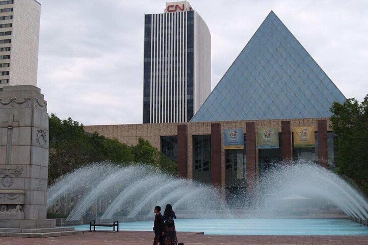 dva lidé stojící před fontánou před budovou