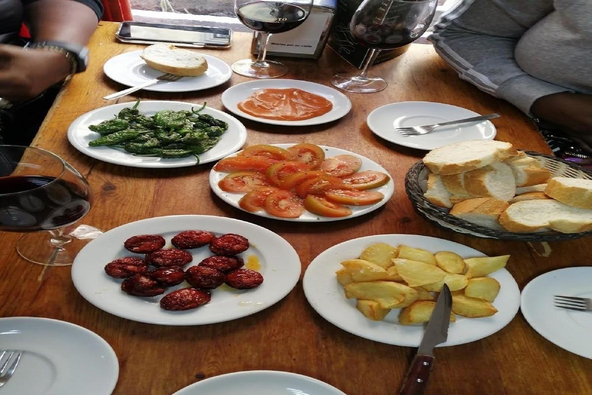 uma mesa de madeira com pratos de comida e copos de vinho