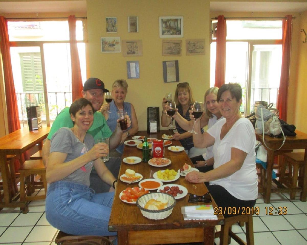 Un grupo de personas sentadas alrededor de una mesa bebiendo vino.