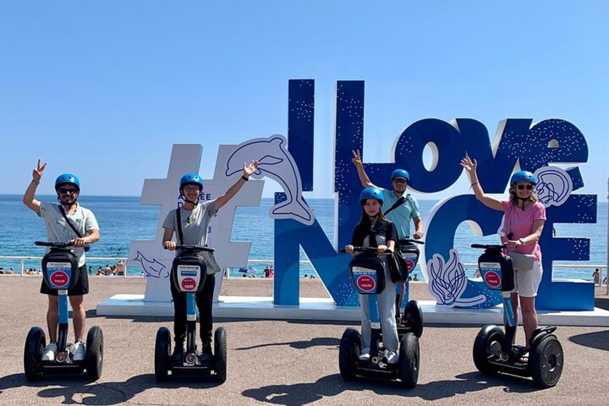 un grup de oameni care se plimbă pe Segway-uri pe plajă