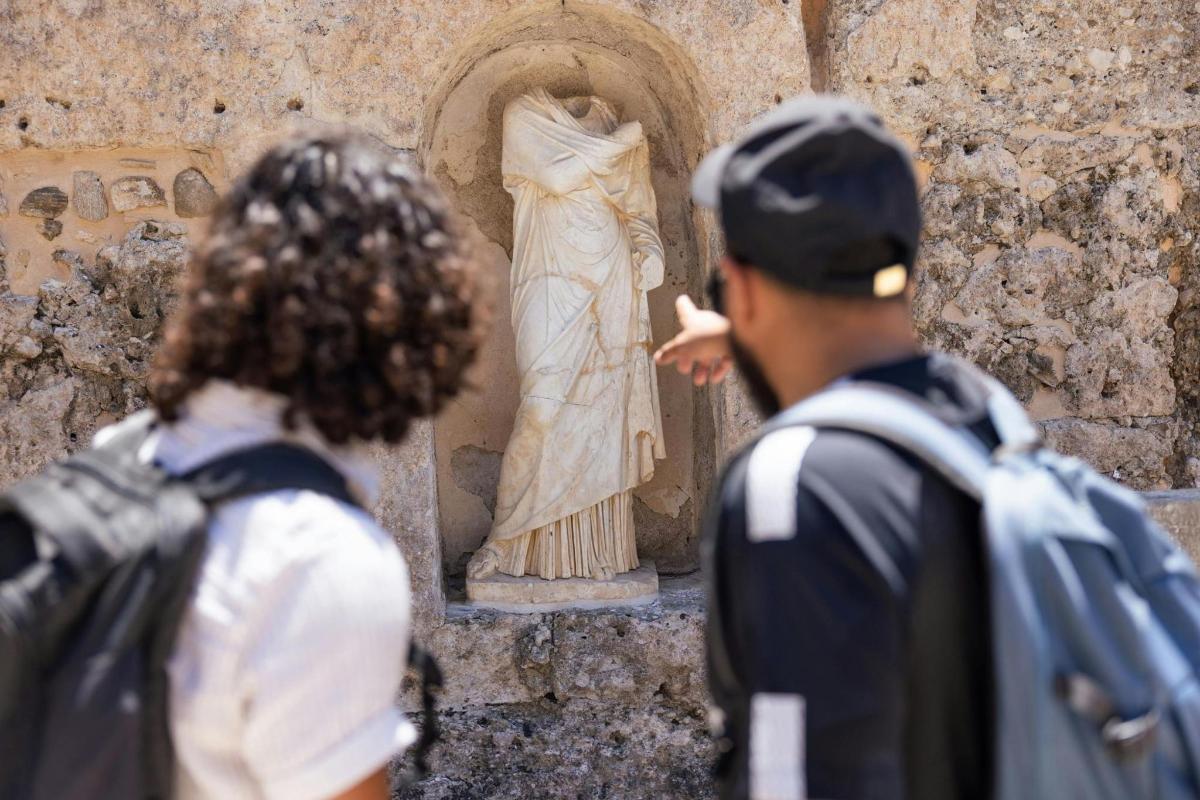 a couple of people looking at a statue