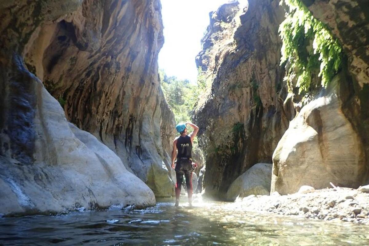 un uomo in piedi nell'acqua in un canyon