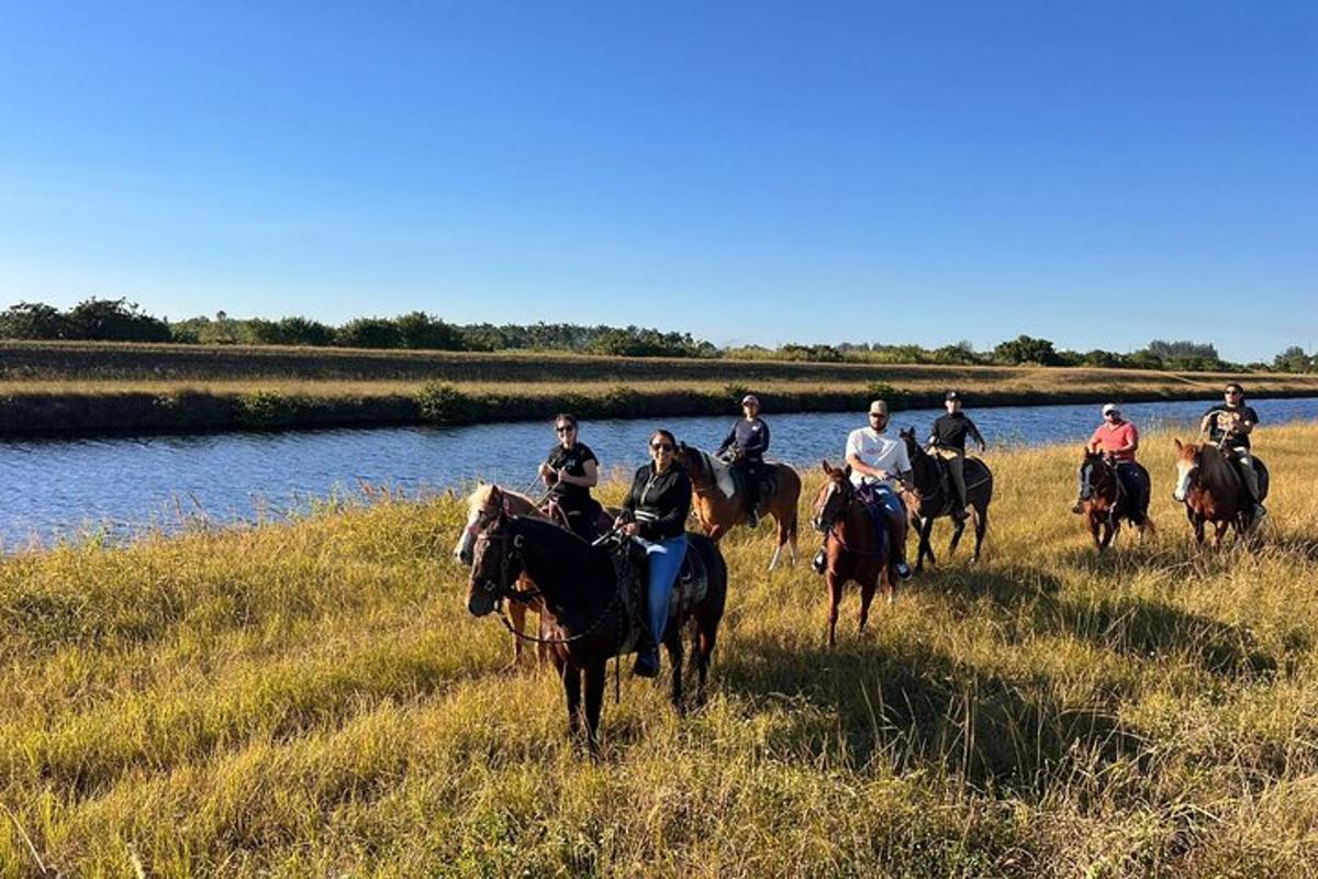 a group of people riding horses in a field