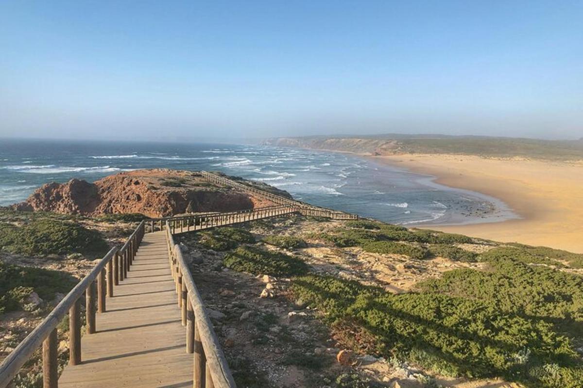 Un paseo marítimo que conduce a una playa con el océano.