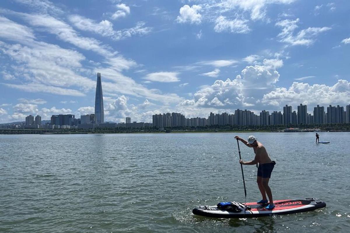 Muž stojí na paddleboardu ve vodě